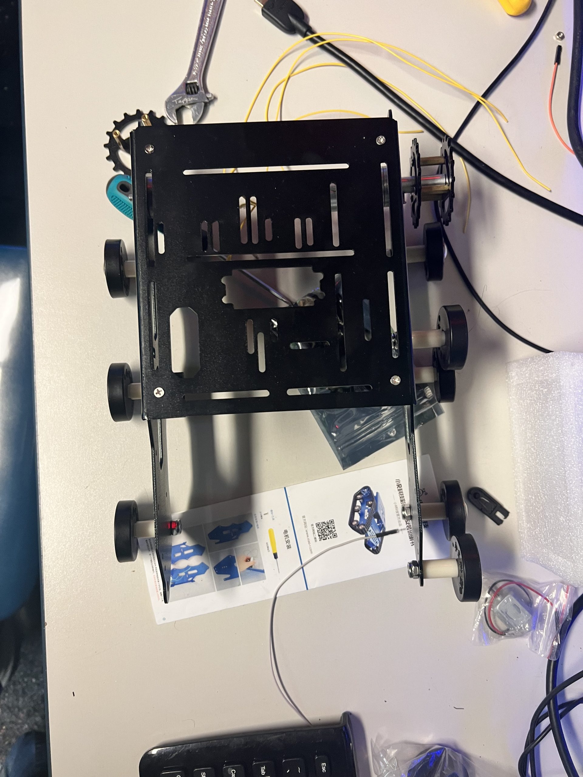 Black metal combat robot chassis with chain drive and sprockets being assembled at Plum Crazy Robotics