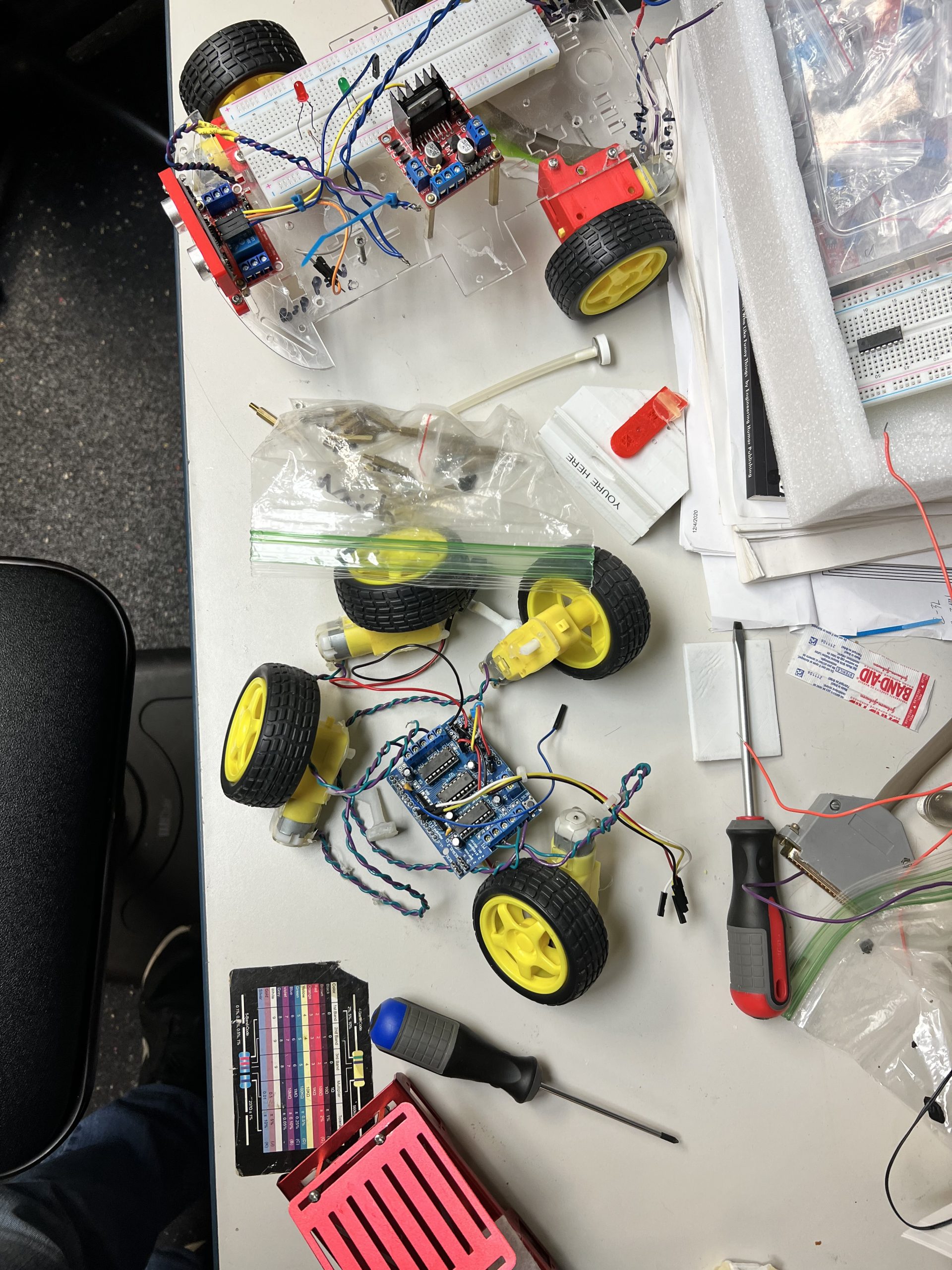 Robot car with Arduino breadboard and motor driver being assembled at Plum Crazy Robotics class