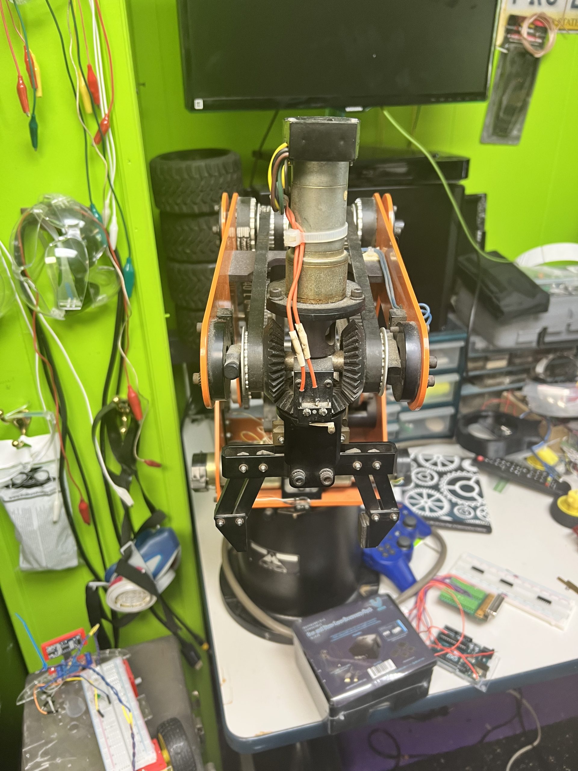 SCORBOT robotic arm front view with gears and gripper at Plum Crazy Robotics workshop Marlboro NJ