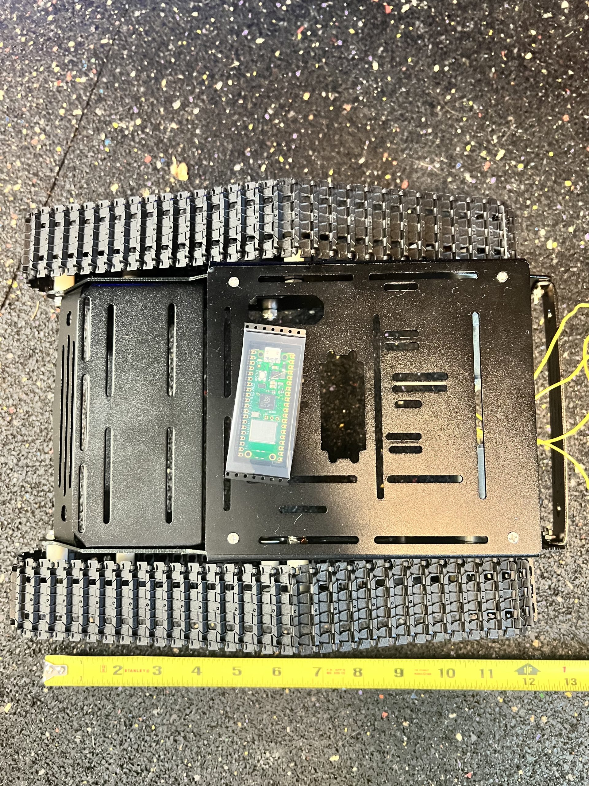 Top view of tracked robot chassis with Raspberry Pi Pico board at Plum Crazy Robotics lab