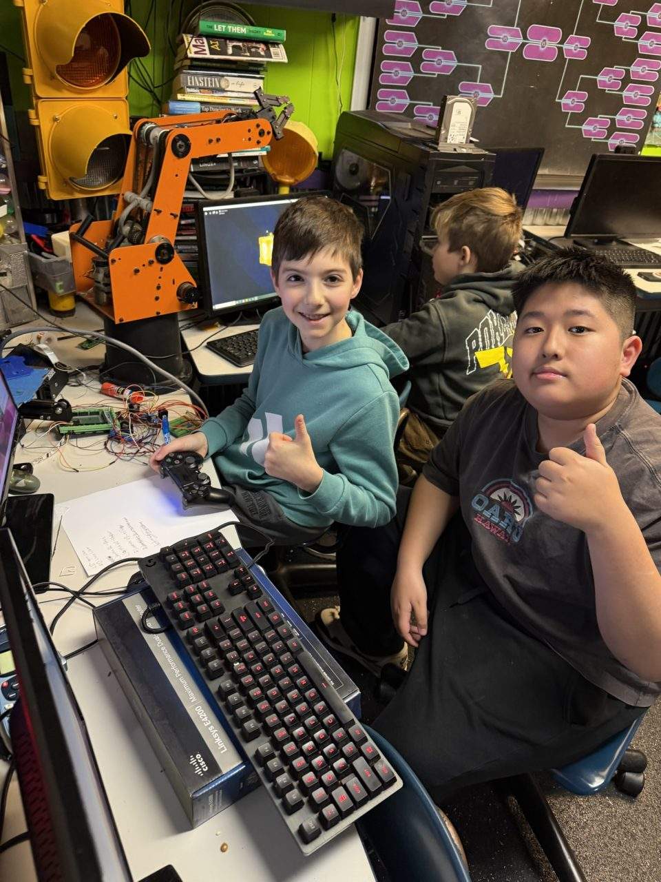 Students with SCORBOT robotic arm and PS4 controller during Arduino robotics class at Plum Crazy Robotics Marlboro NJ