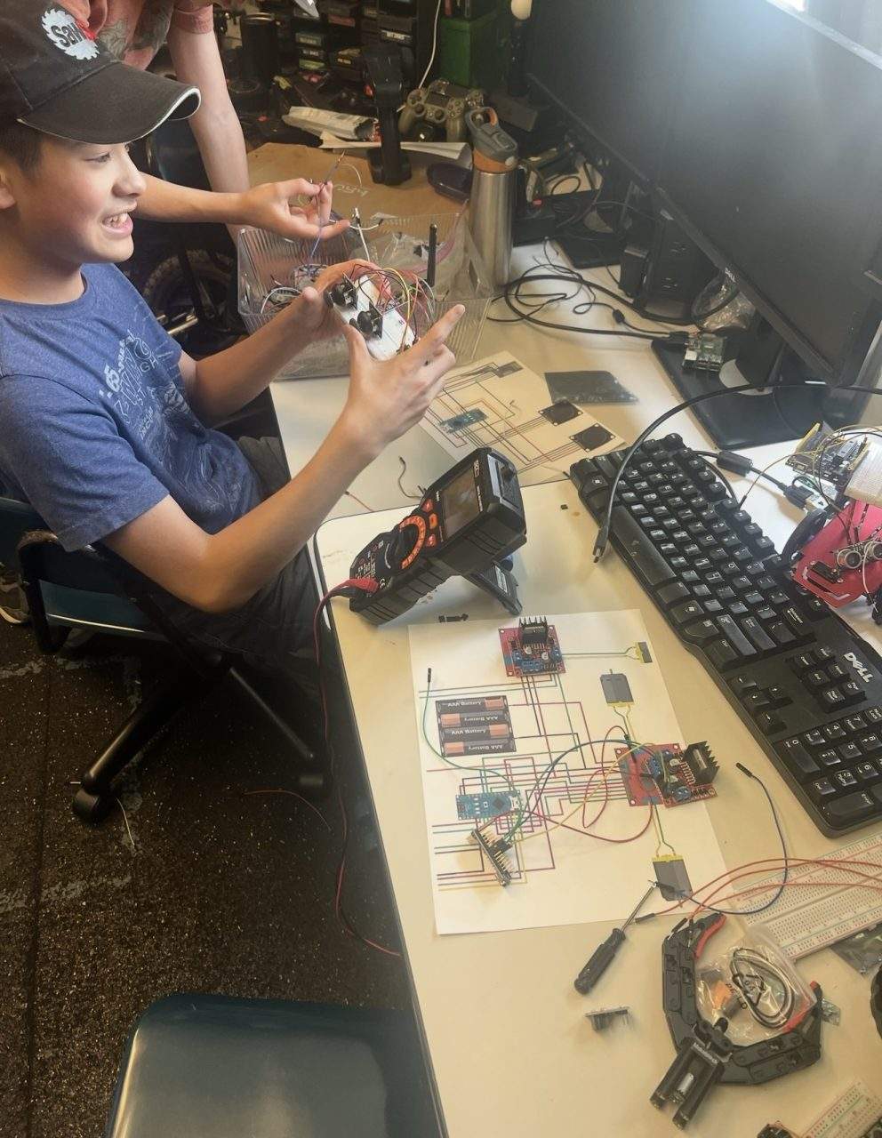 Student wiring Arduino motor controller with breadboard and circuit diagram at Plum Crazy Robotics