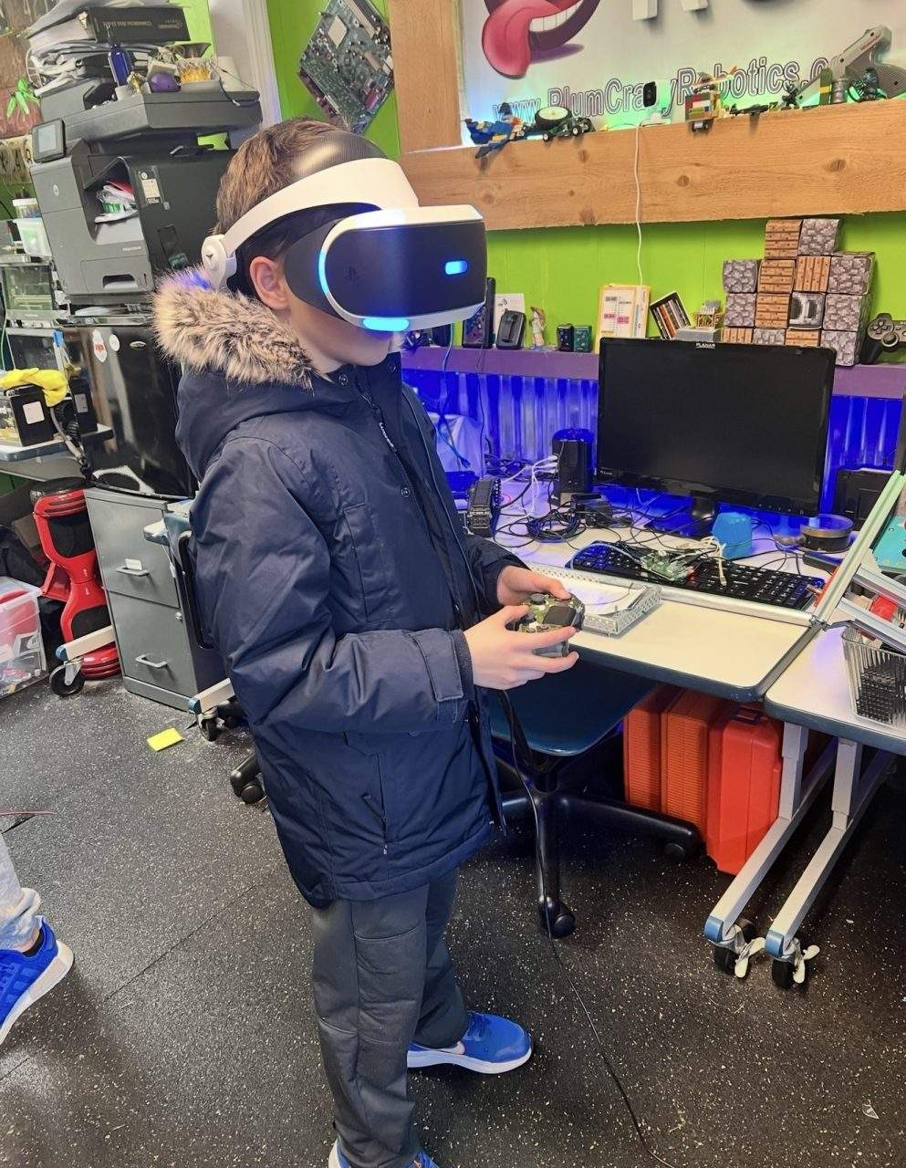 Student wearing VR headset with PS4 controller at Plum Crazy Robotics lab Marlboro NJ