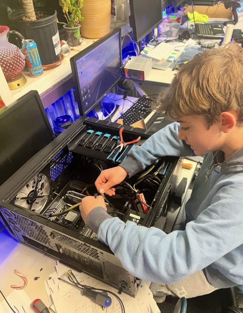 Student routing cables inside gaming PC build with RGB fans at Plum Crazy Robotics Marlboro NJ